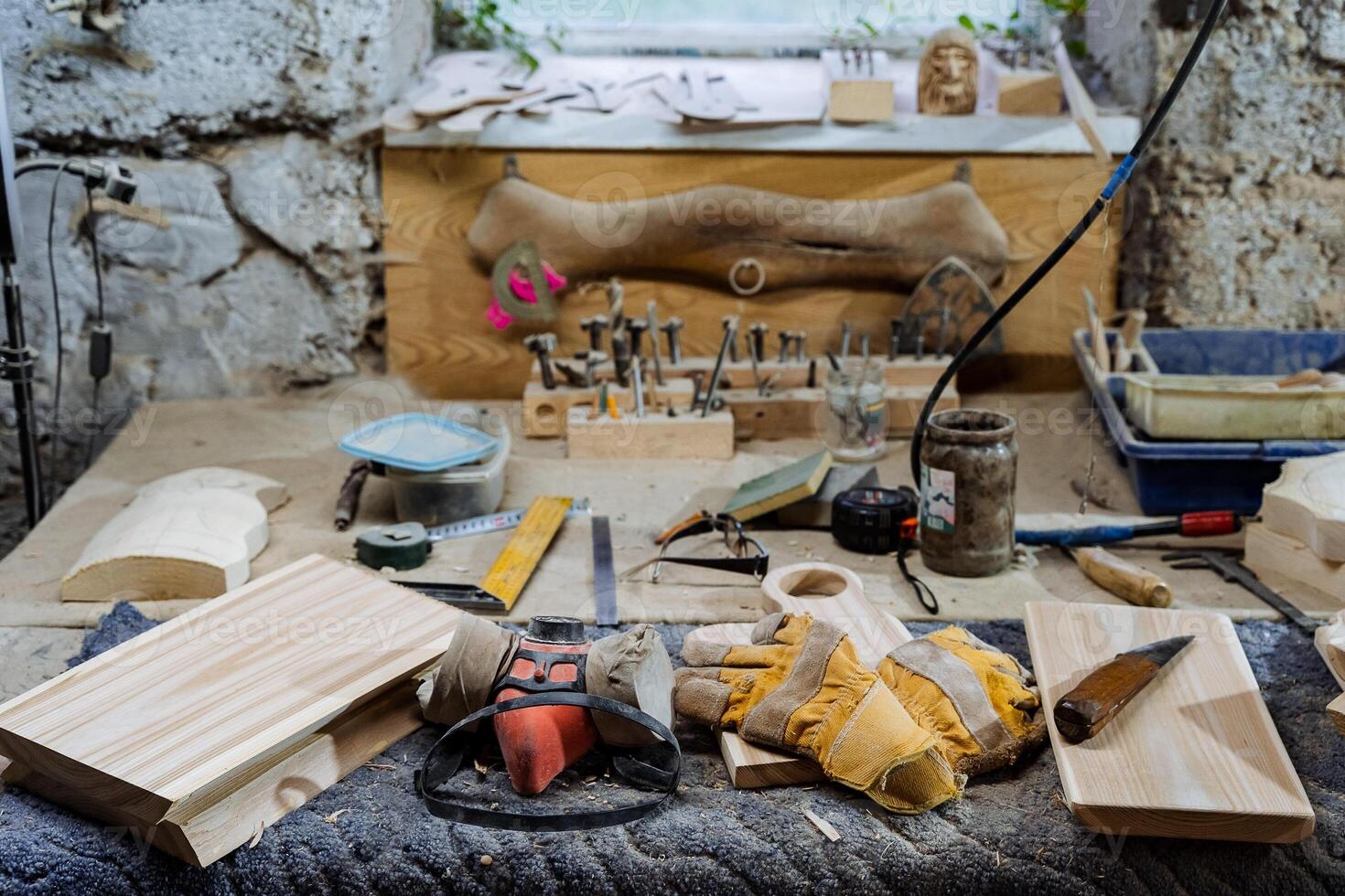 carpentry workshop with tools for woodworking, workbench for working with boards, dust mask and leather gloves, a set of wooden blanks for cutting boards, shop photo