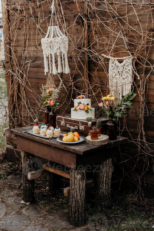kendybar on the table is a cake muffins cupcakes, sweet treats for children, catering design in boho style, wedding table design, rustic style with macrame elements photo