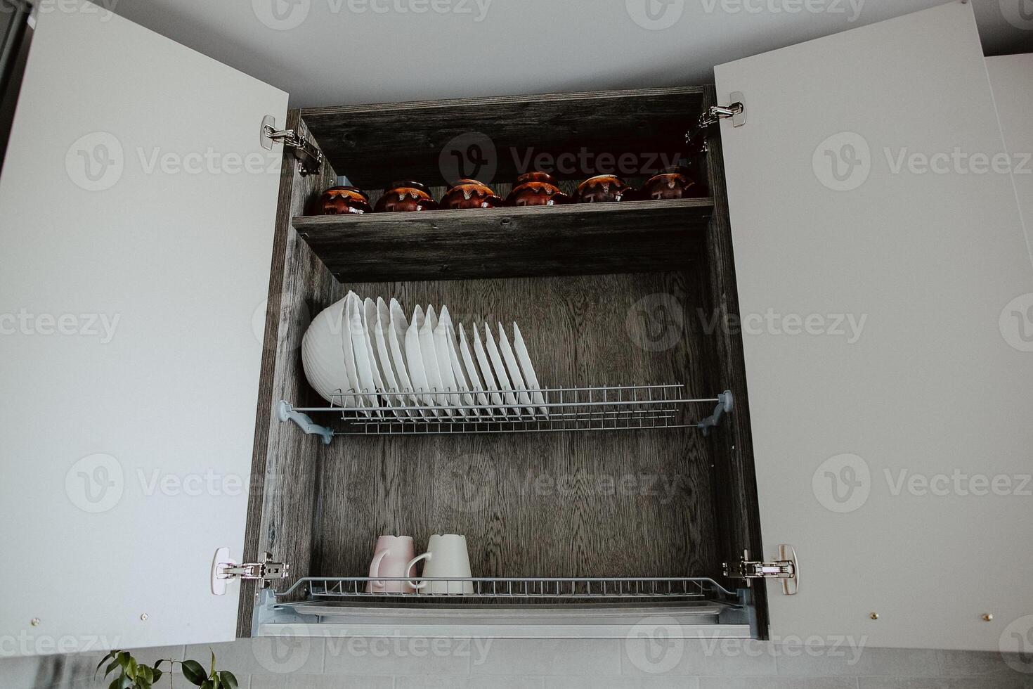 Order in the kitchen. Dishes in the kitchen are in a drawer. Arrange the plates and lids in their places. photo
