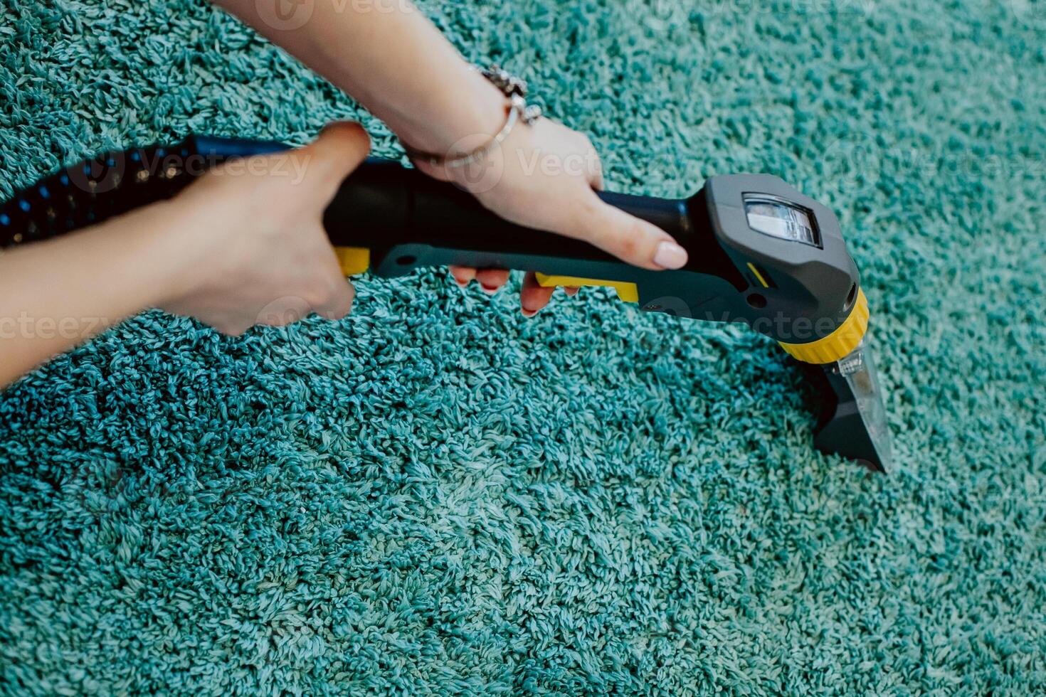 carpet cleaning, vacuum cleaner tube in women's hands cleans the carpet, the concept of cleanliness in the house, apartment cleaning, textile cleaning machine, order photo