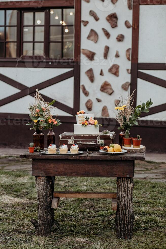 kendybar on the table is a cake muffins cupcakes, sweet treats for children, catering design in boho style, wedding table design, rustic style with macrame elements photo