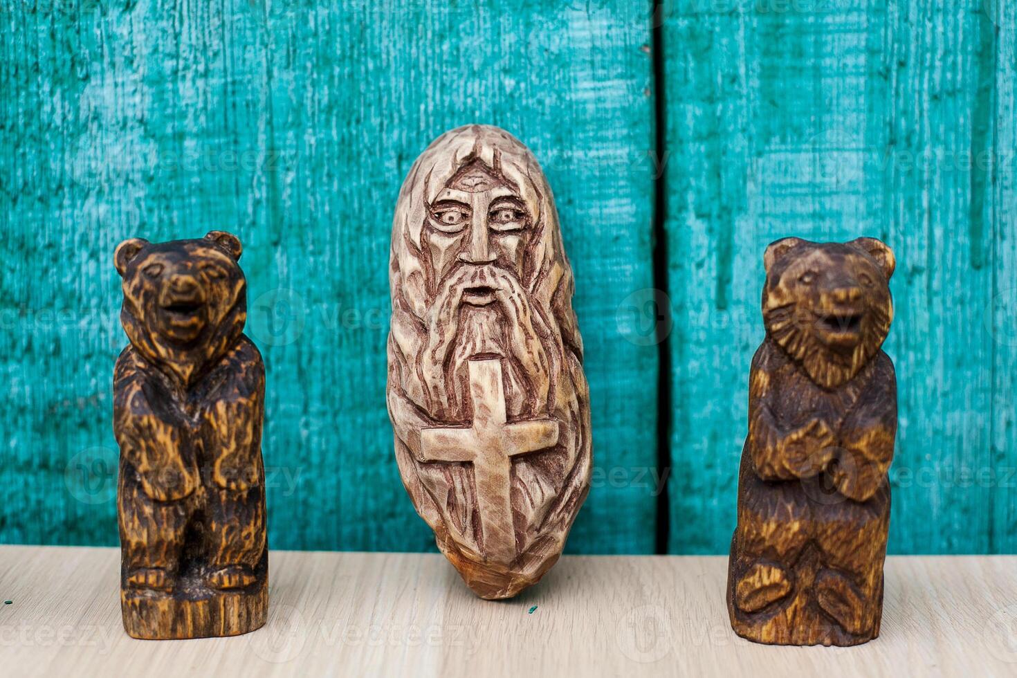 Three wooden figurines of a bear, a man and a bear photo