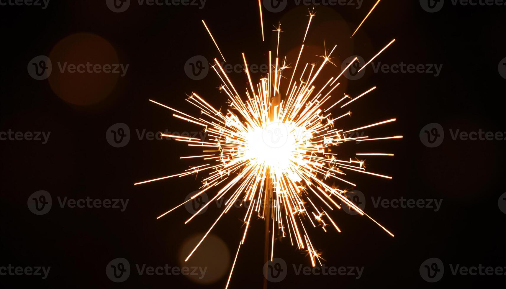 A sparkler is lit up in the dark photo