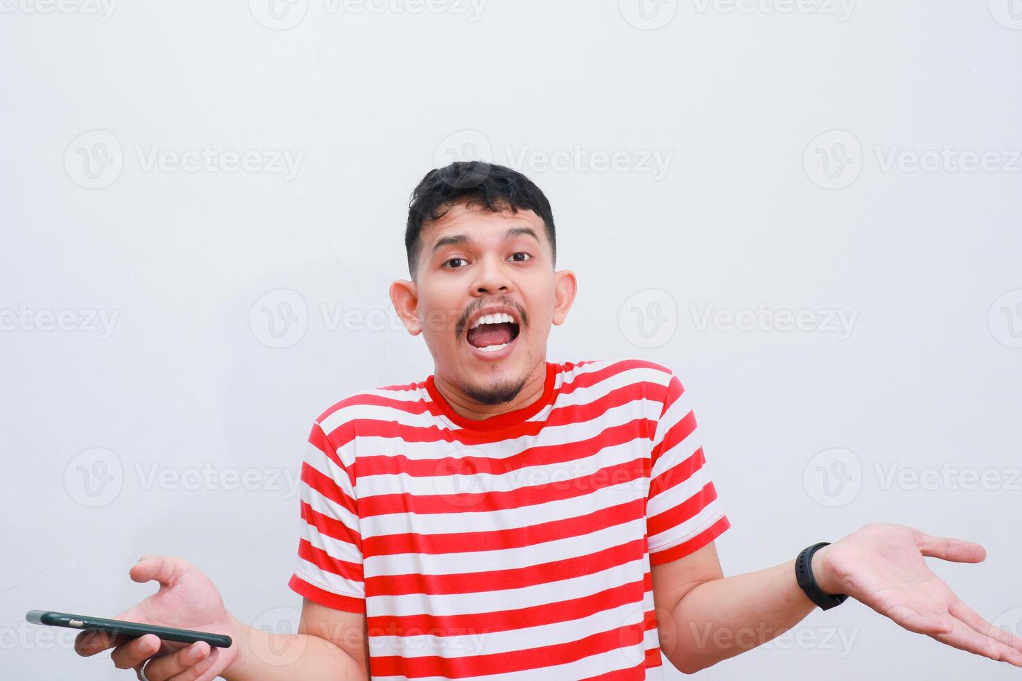 confused asian man while holding his smartphone photo