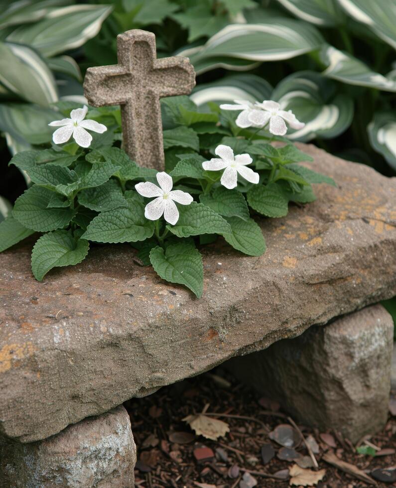 stone cross and white flowers in garden photo