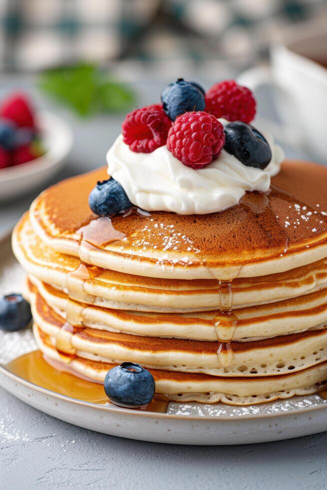 Delicious stack of pancakes with fresh berries and whipped cream photo