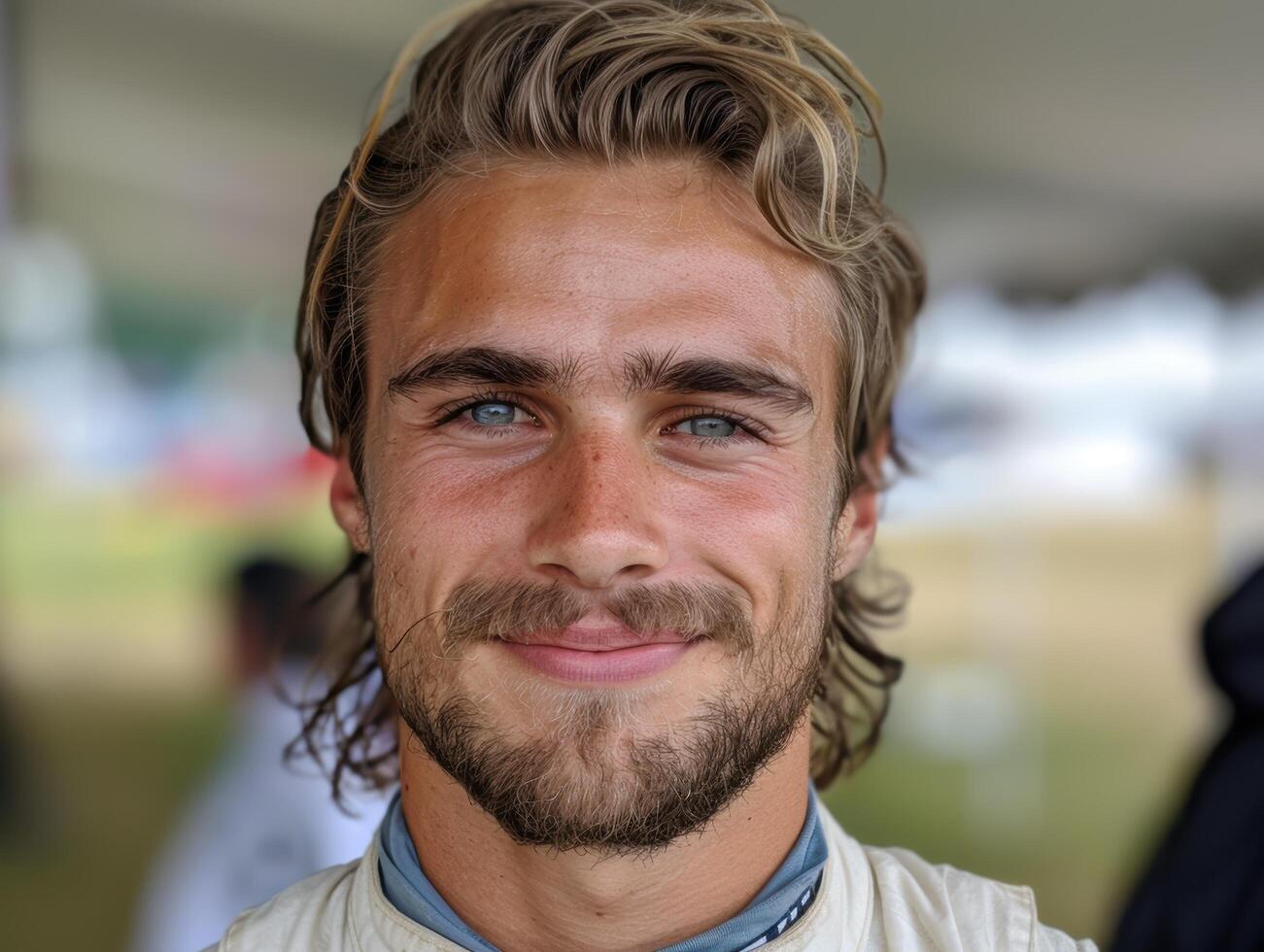 Handsome young man with curly hair and beard smiling photo