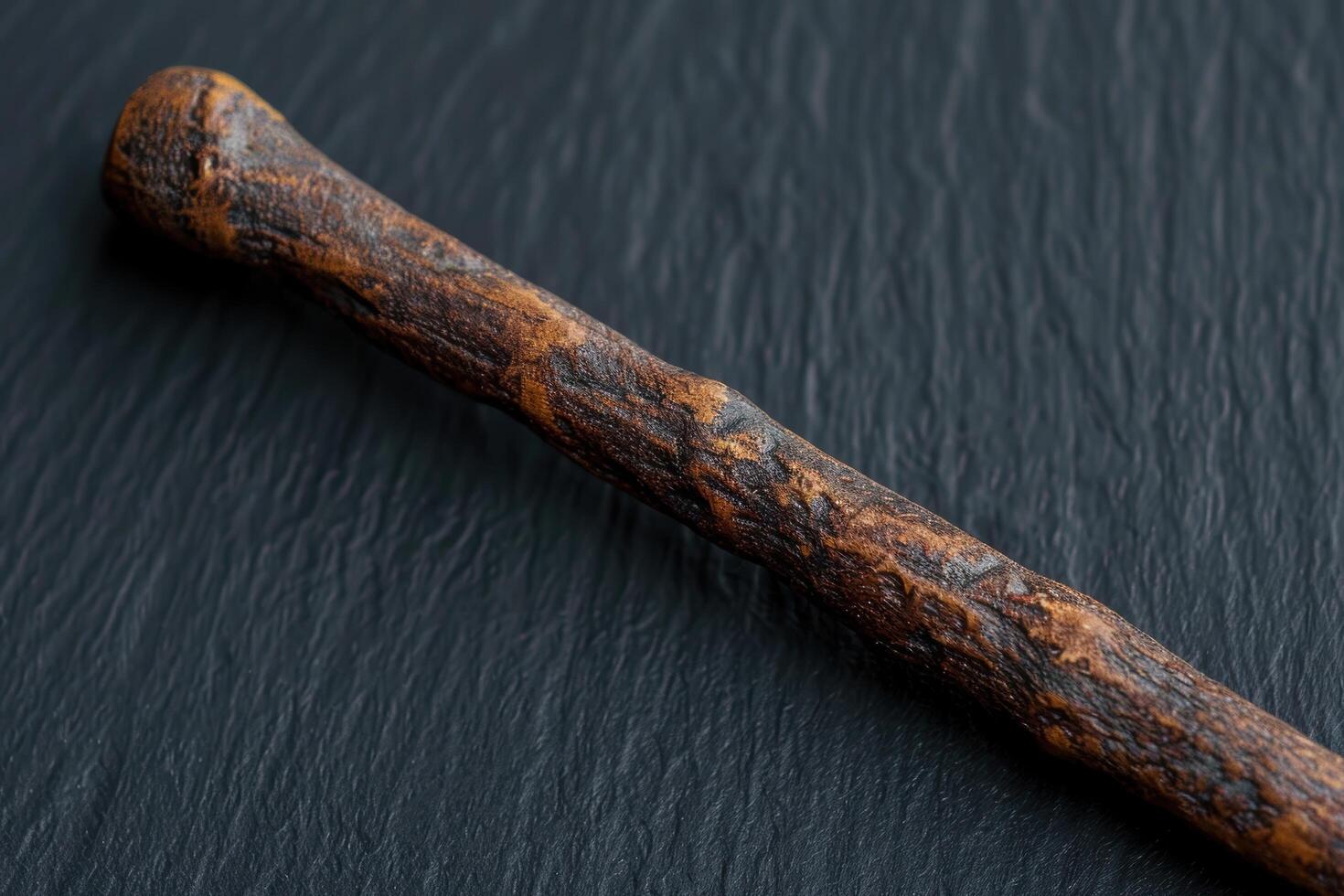 Closeup of a rustic wooden stick on a dark background photo