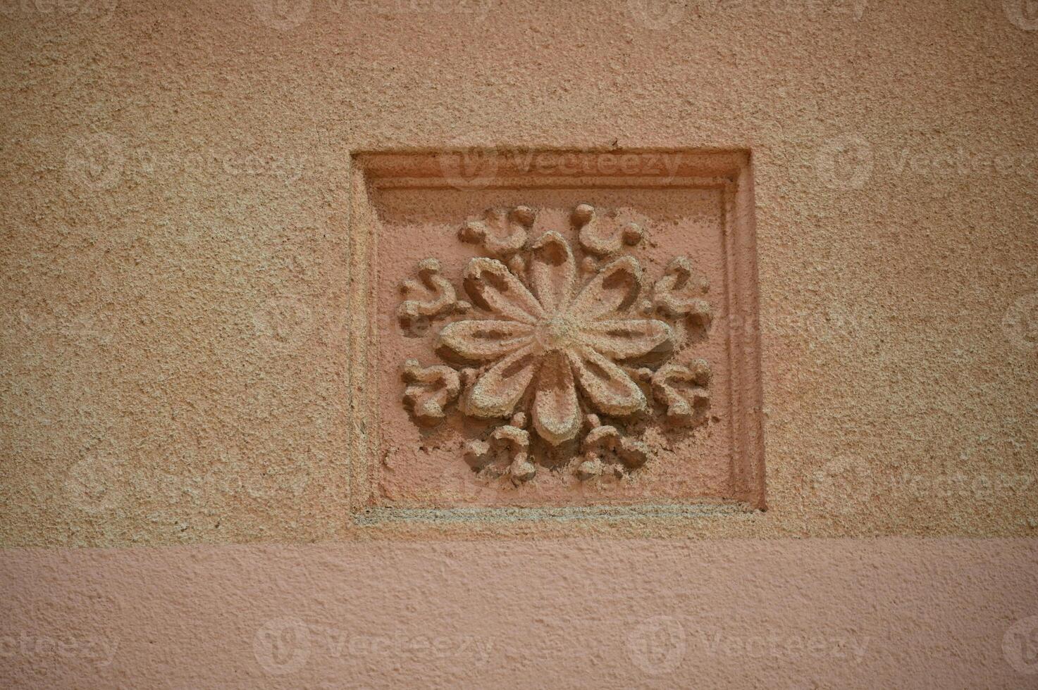 a decorative flower on a pink wall photo