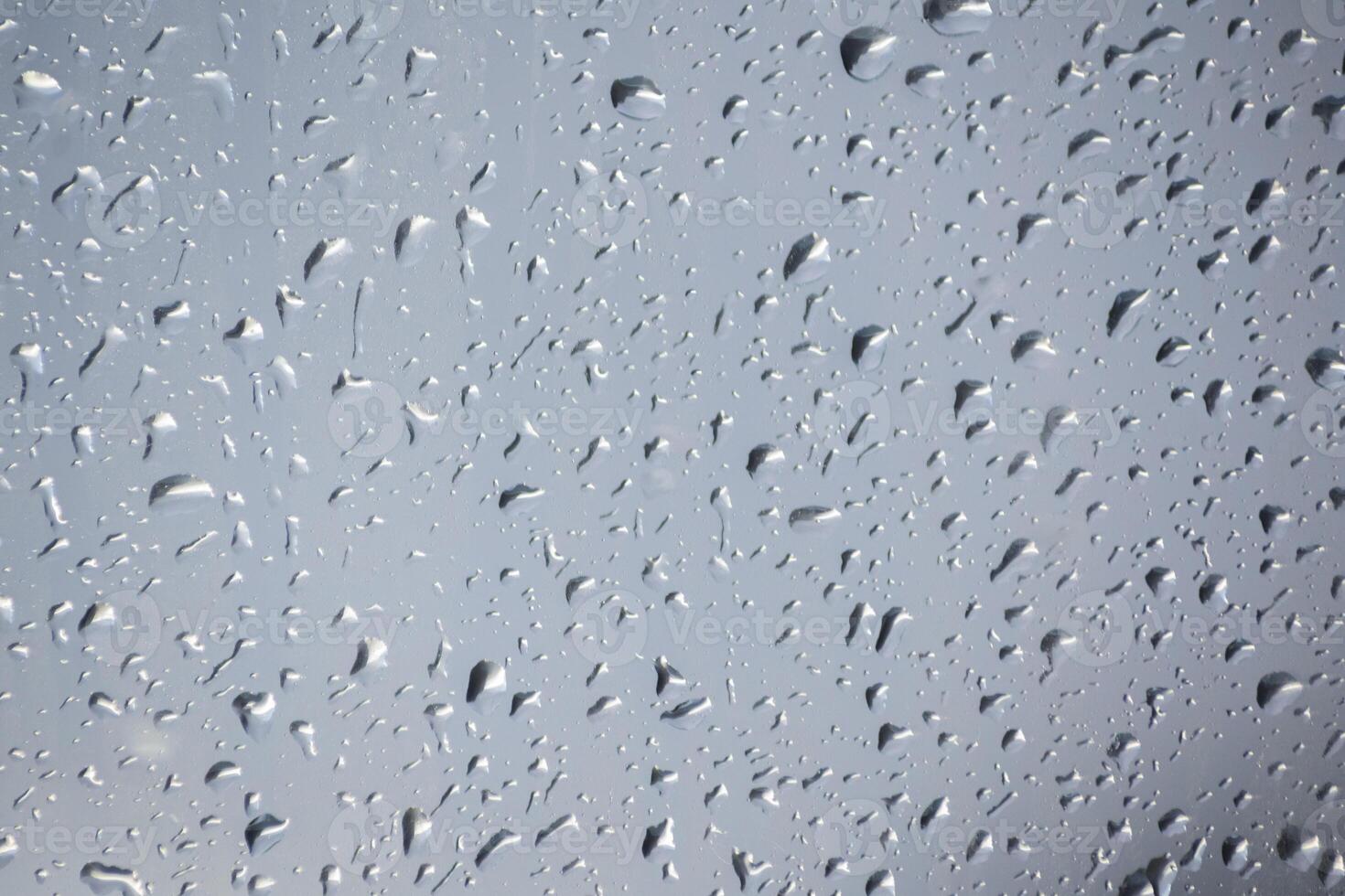 Raindrops on a window indicating gray and rainy day photo