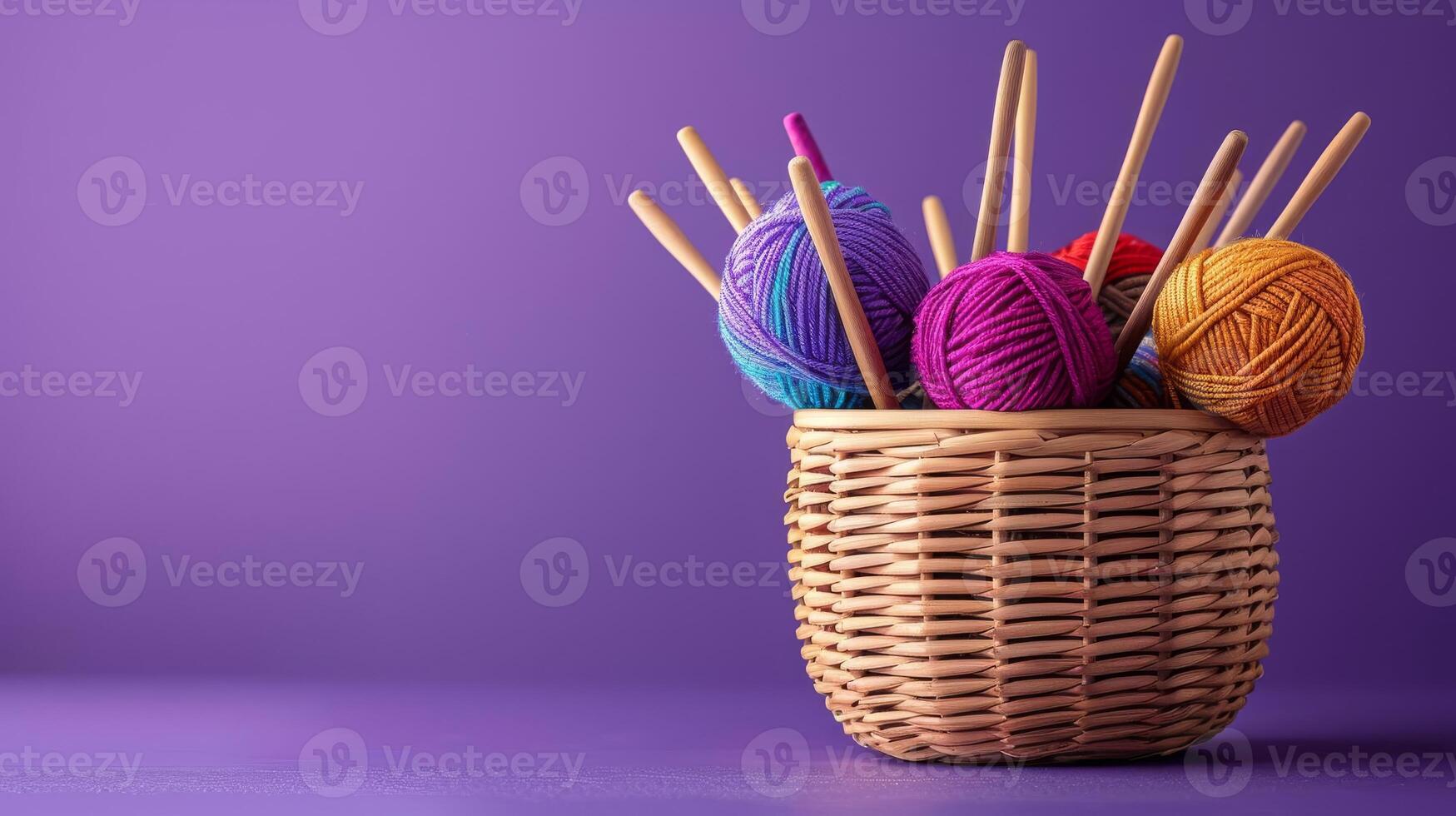 A beautiful still life of a wicker basket filled with colorful yarn and knitting needles on a purple background. The perfect image for a knitting or crocheting enthusiast. photo