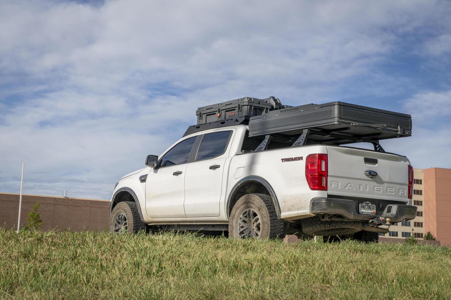 Loveland, CO, USA - August 25, 2024 - Ford Ranger Tremor truck with racks, roof tent and cargo box. photo