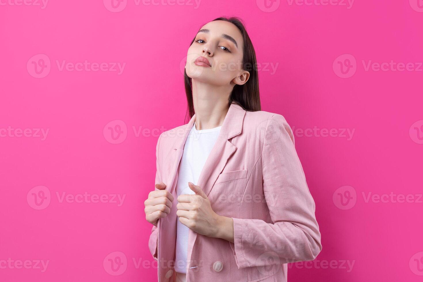 Portrait of beautiful young woman in pink jacket thinking isolated on red background photo