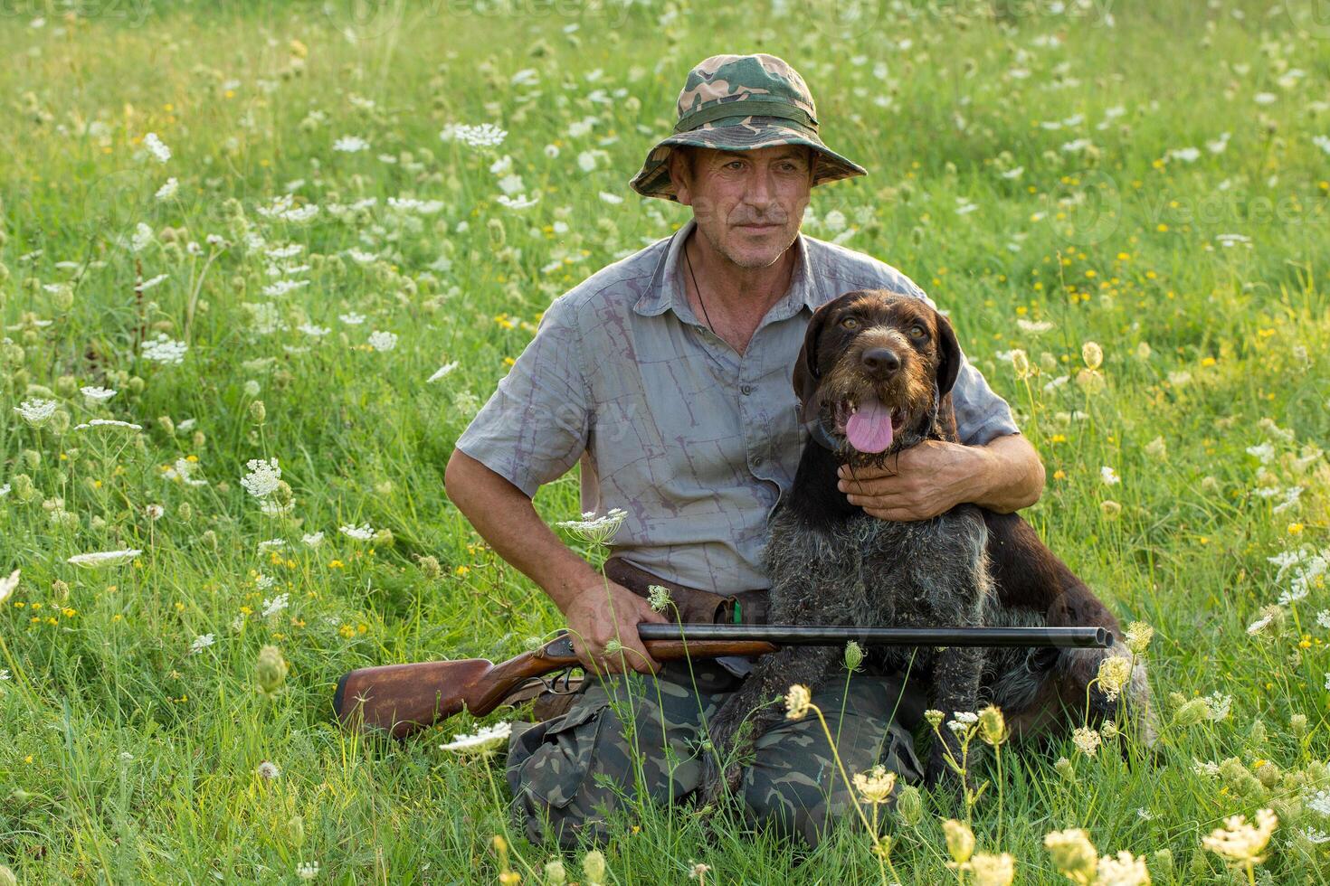 Hunter man in camouflage with a gun during the hunt in search of wild birds or game. photo