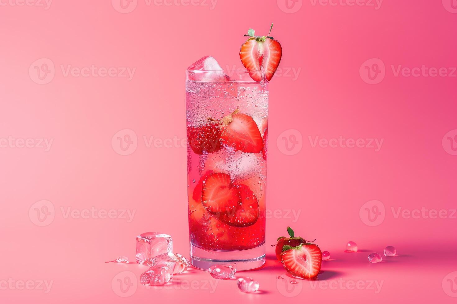 A Glass of Sparkling Strawberry Lemonade with Ice Cubes and Strawberries on a Pink Background photo