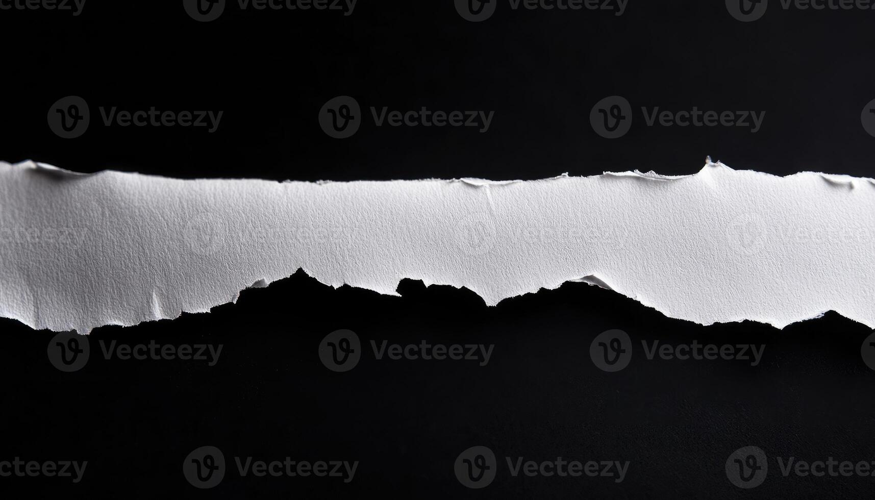 A Single Torn Strip of White Paper on a Black Background photo