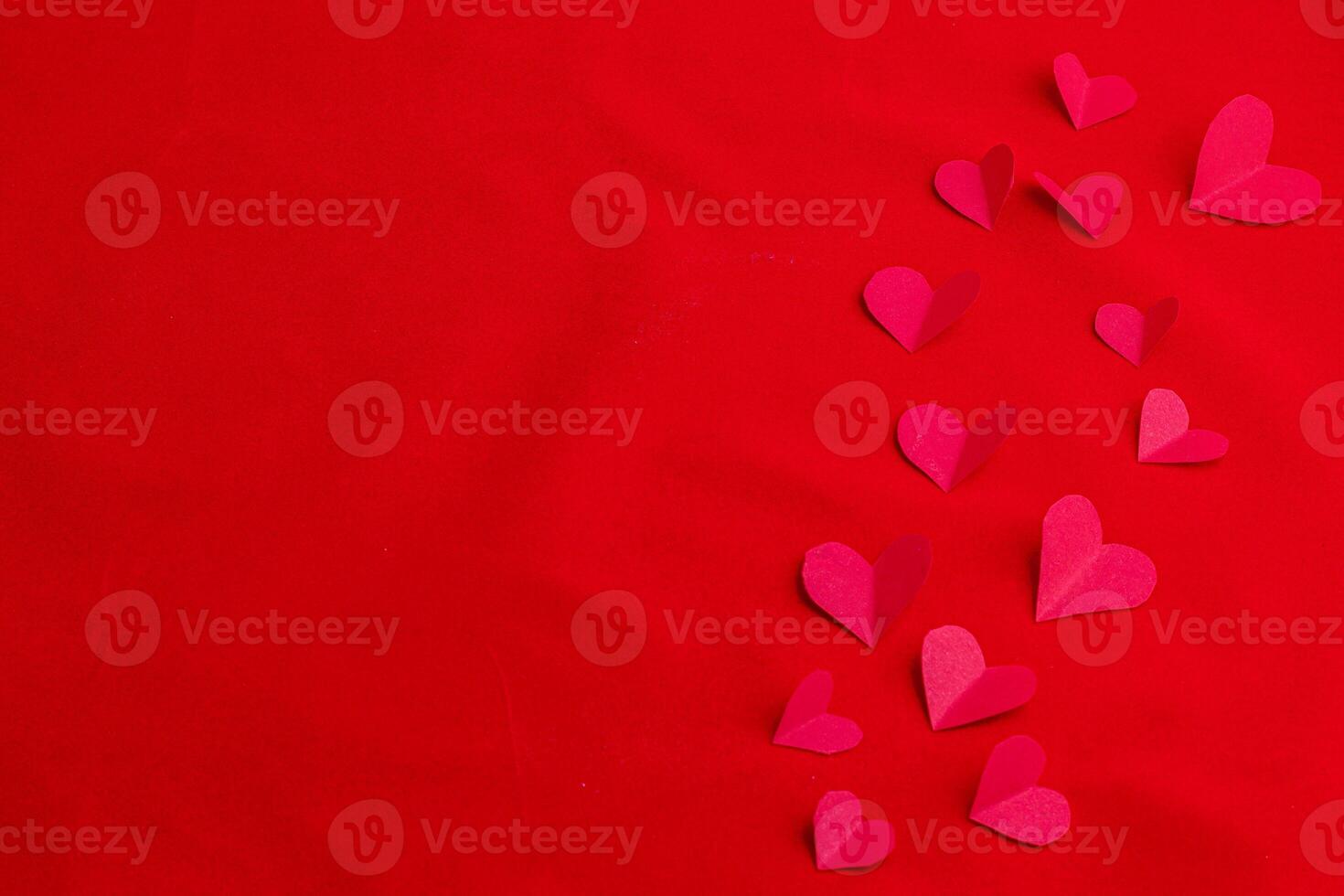 Composition for Valentine's Day with cut out hearts on a red background photo