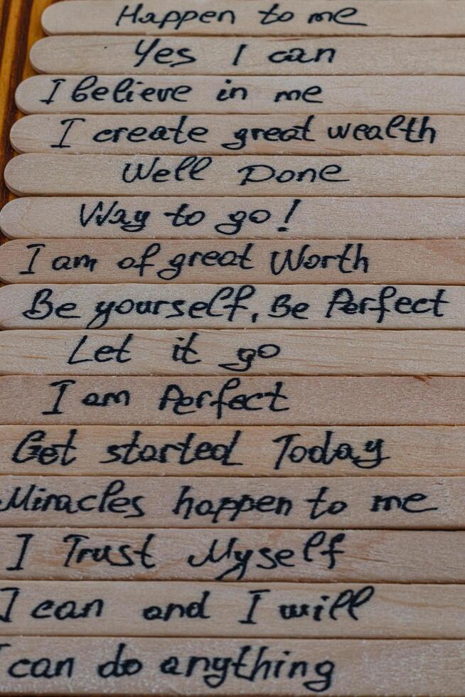 Good positive thoughts to increase self esteem are written on wooden sticks photo