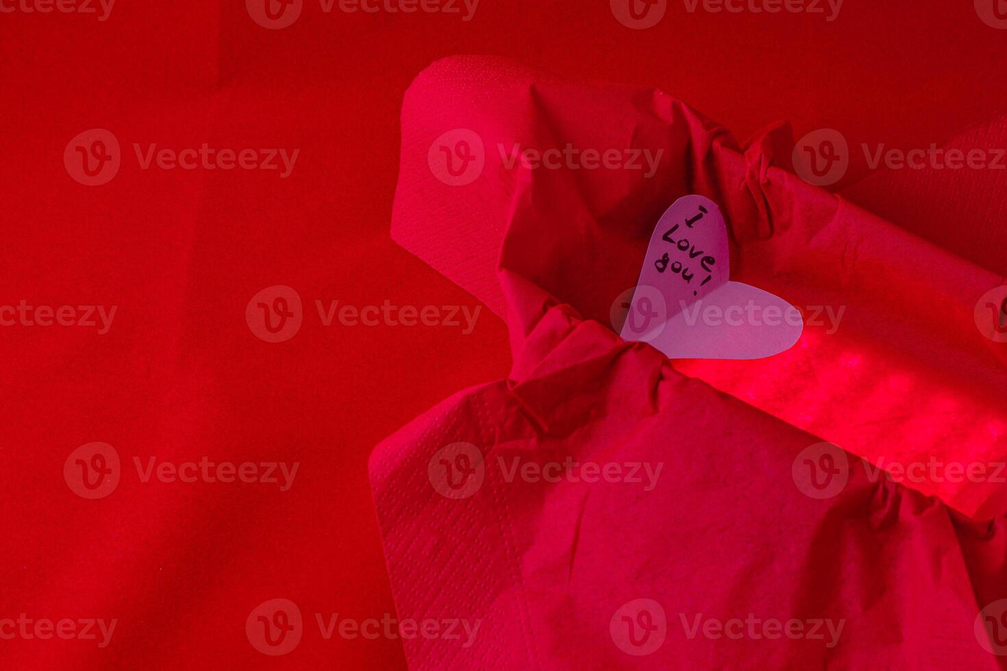 hand cut heart made from paper inside of a red box with a back light for effect photo