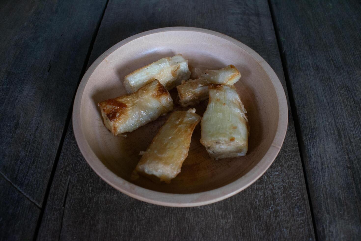 Fried cassava food served on a wooden bowl photo
