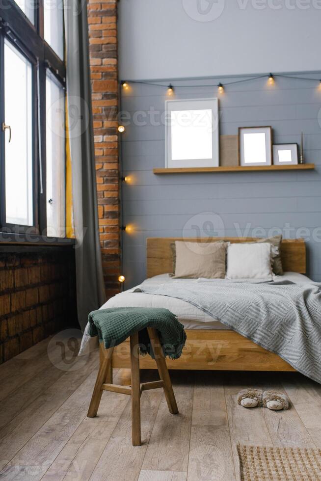 Green blanket on the stool by the bed in the bedroom in the Scandinavian style photo