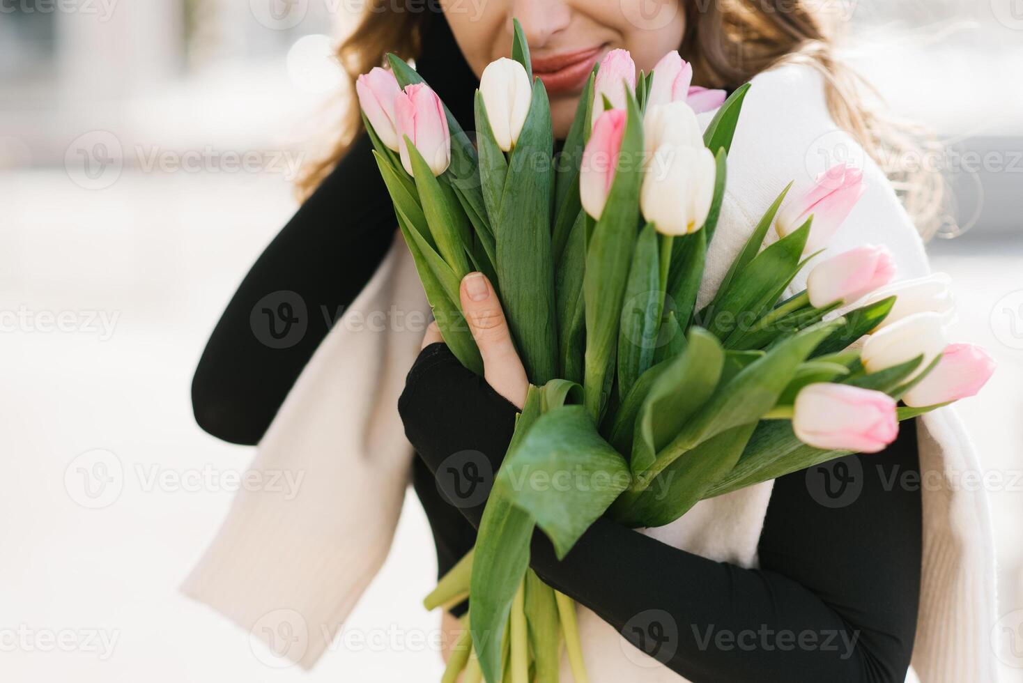 Close up bouquet of spring flowers of tulips in the hands of a woman photo