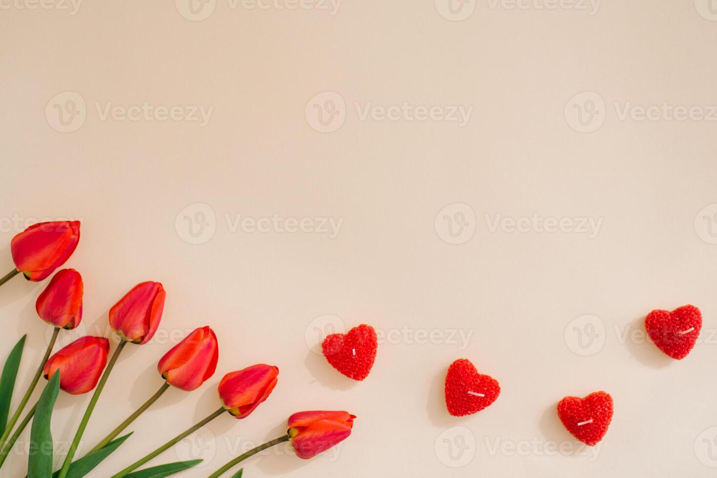 Flat lay valentines day frame with red tulips and and red heart on a light background with copy space photo
