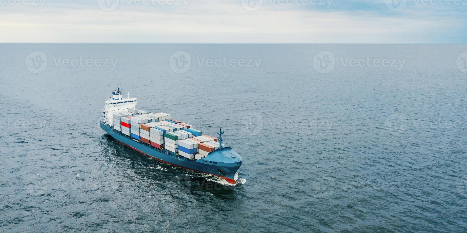 Aerial view of blue cargo vessel carrying containers in the sea photo
