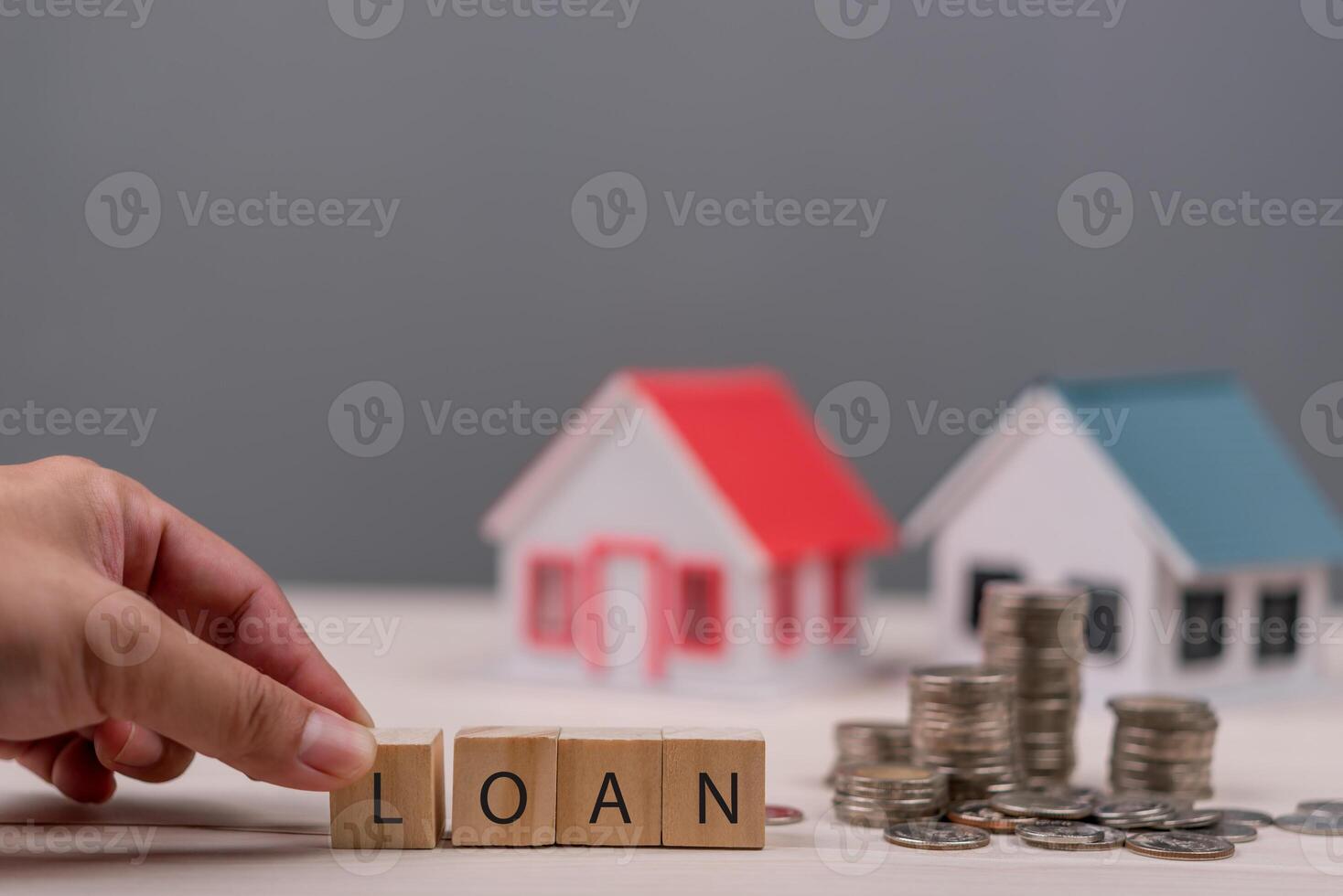 Loan concept with house and coins on table photo