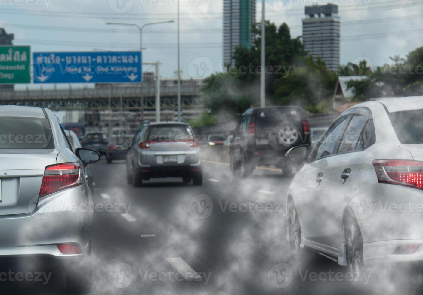 Cars driving on a highway with smoke coming out of the exhaust photo