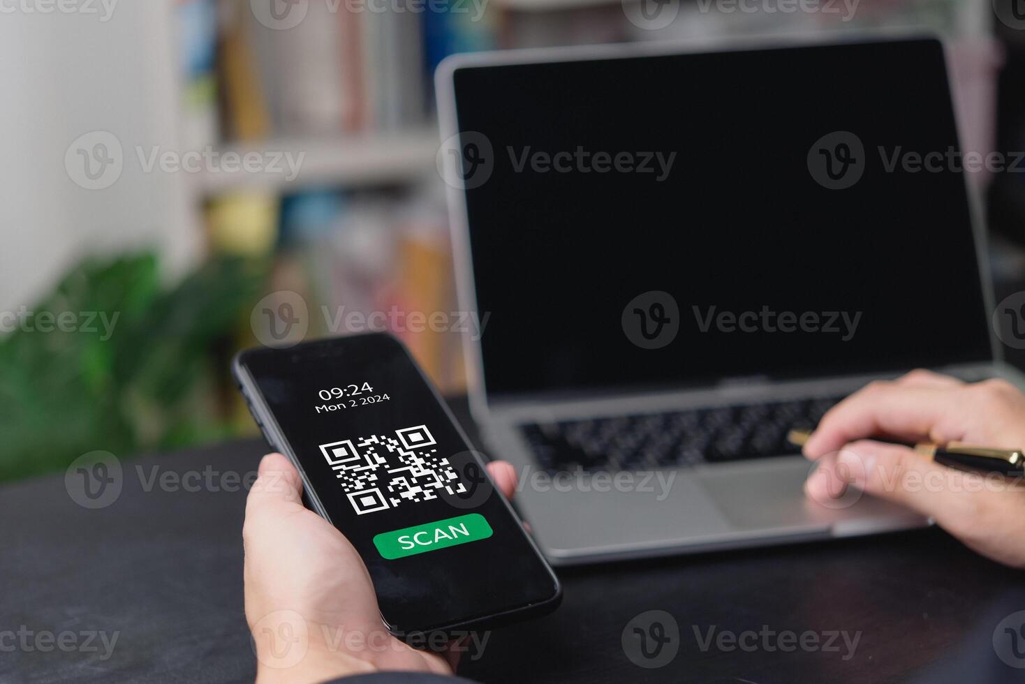 A man using a smartphone to scan a qr code on a laptop photo