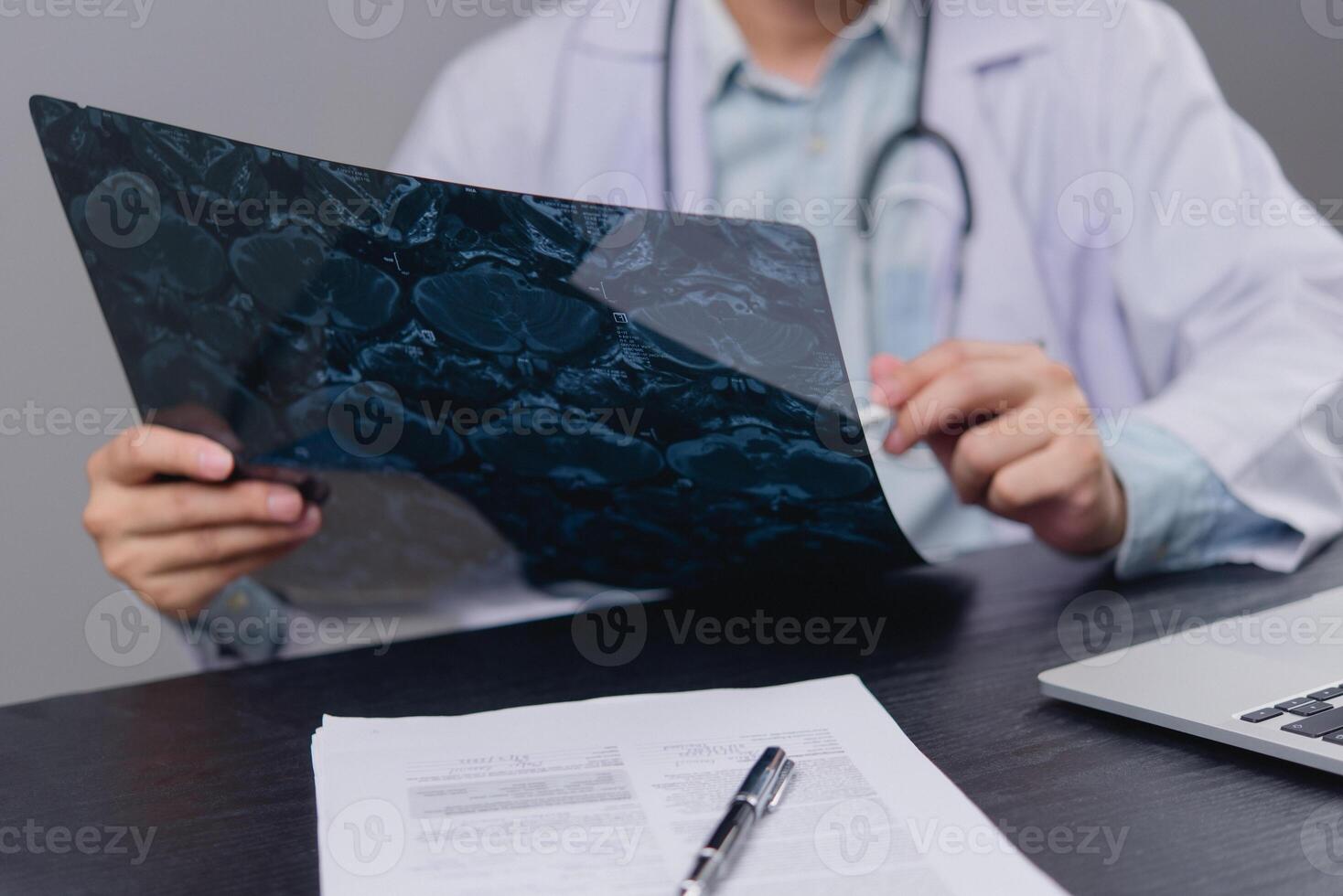 A man in a lab coat is holding a piece of paper photo