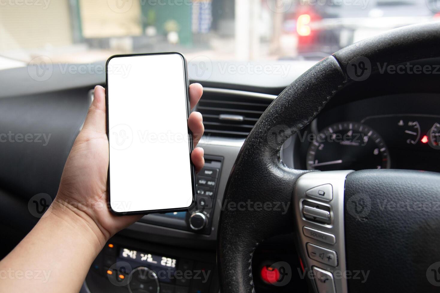 Man holding smartphone in the car with blank screen photo