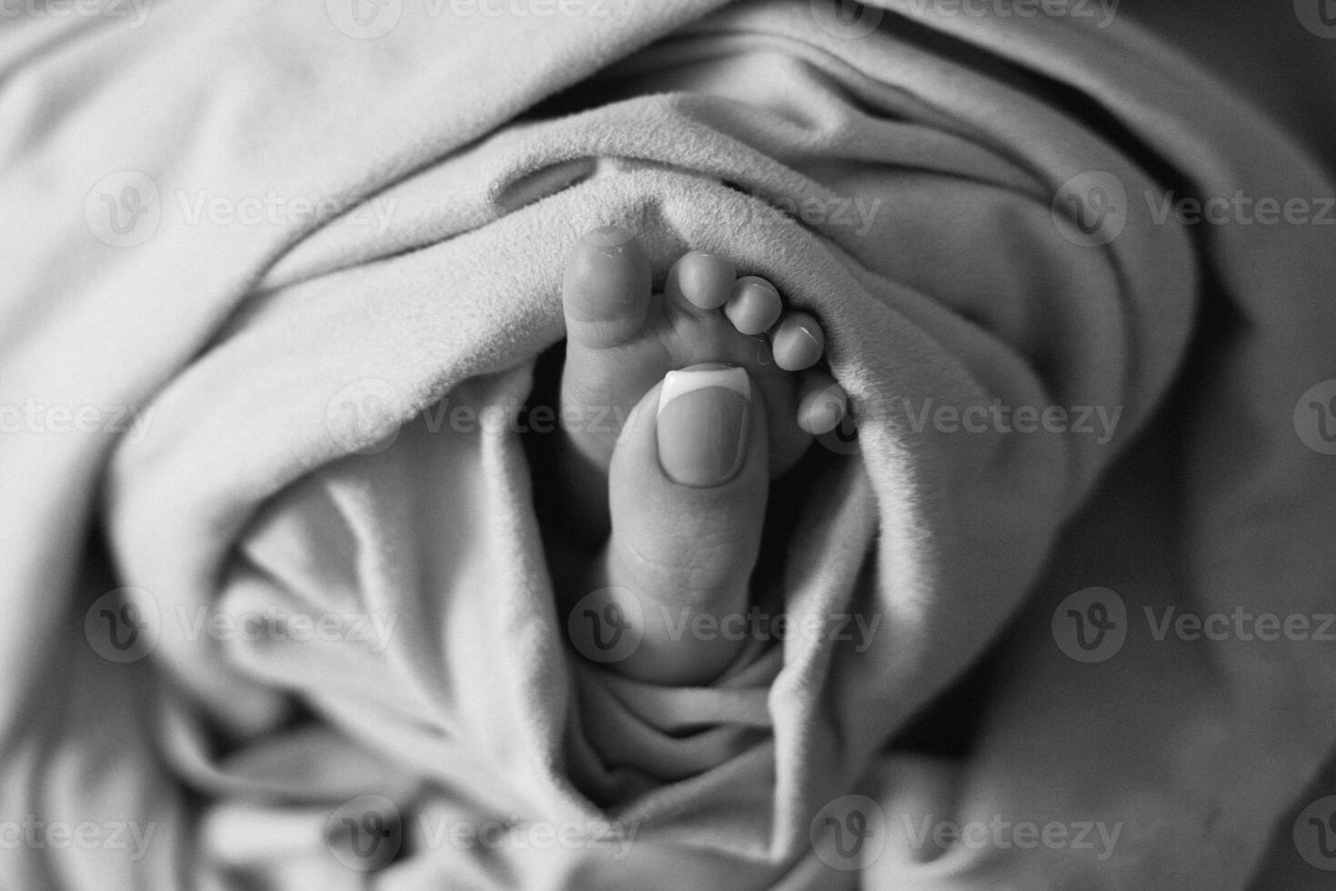 A black and white photo of a person's feet under a blanket