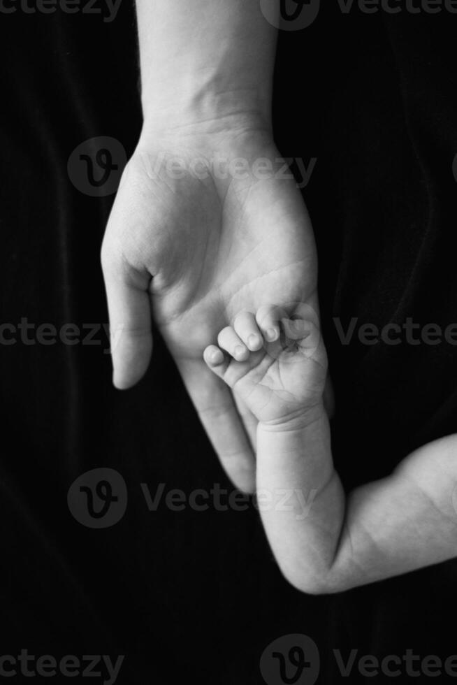 A black and white photo of a baby's hand