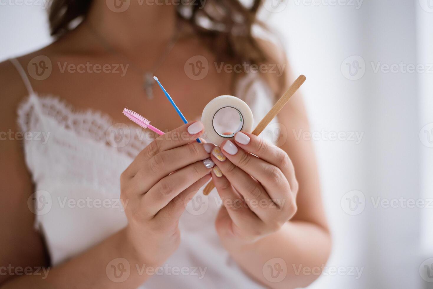 A woman holding a toothbrush and a toothpaste tube photo
