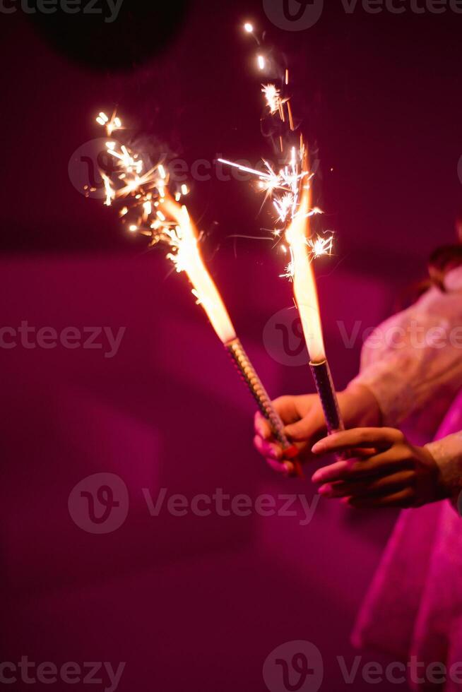 A person holding two sparklers in their hands photo