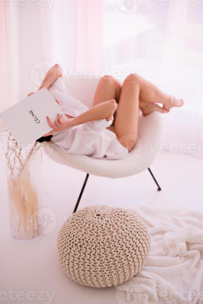 A woman laying on a chair reading a book photo