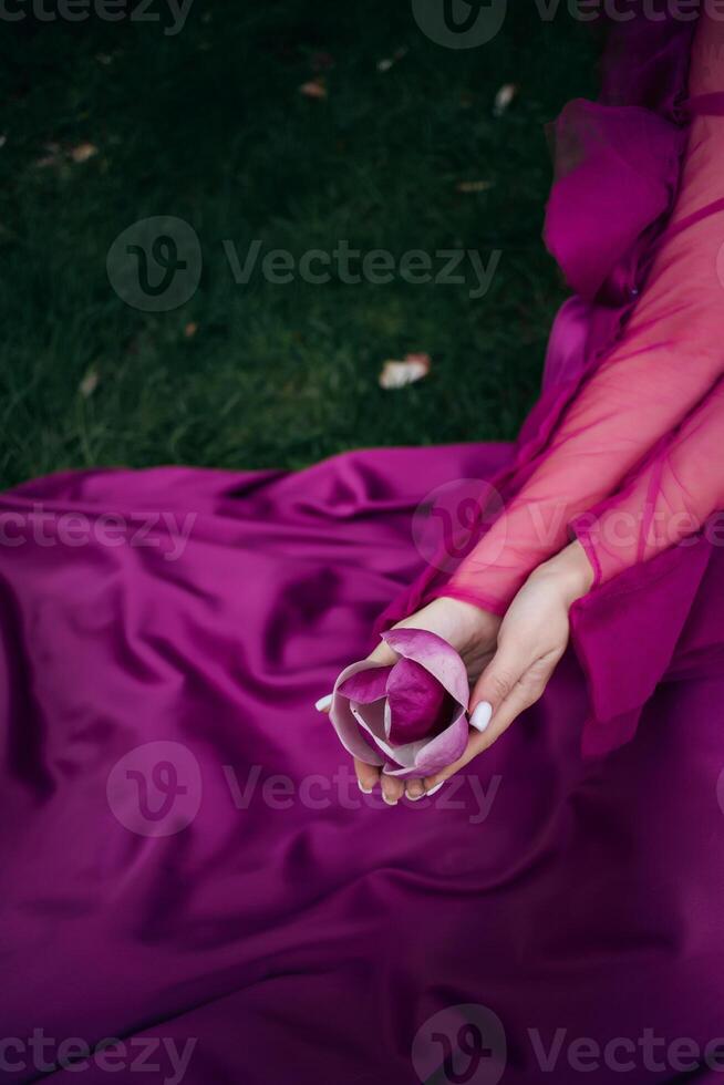 A woman in a purple dress holding a ring photo