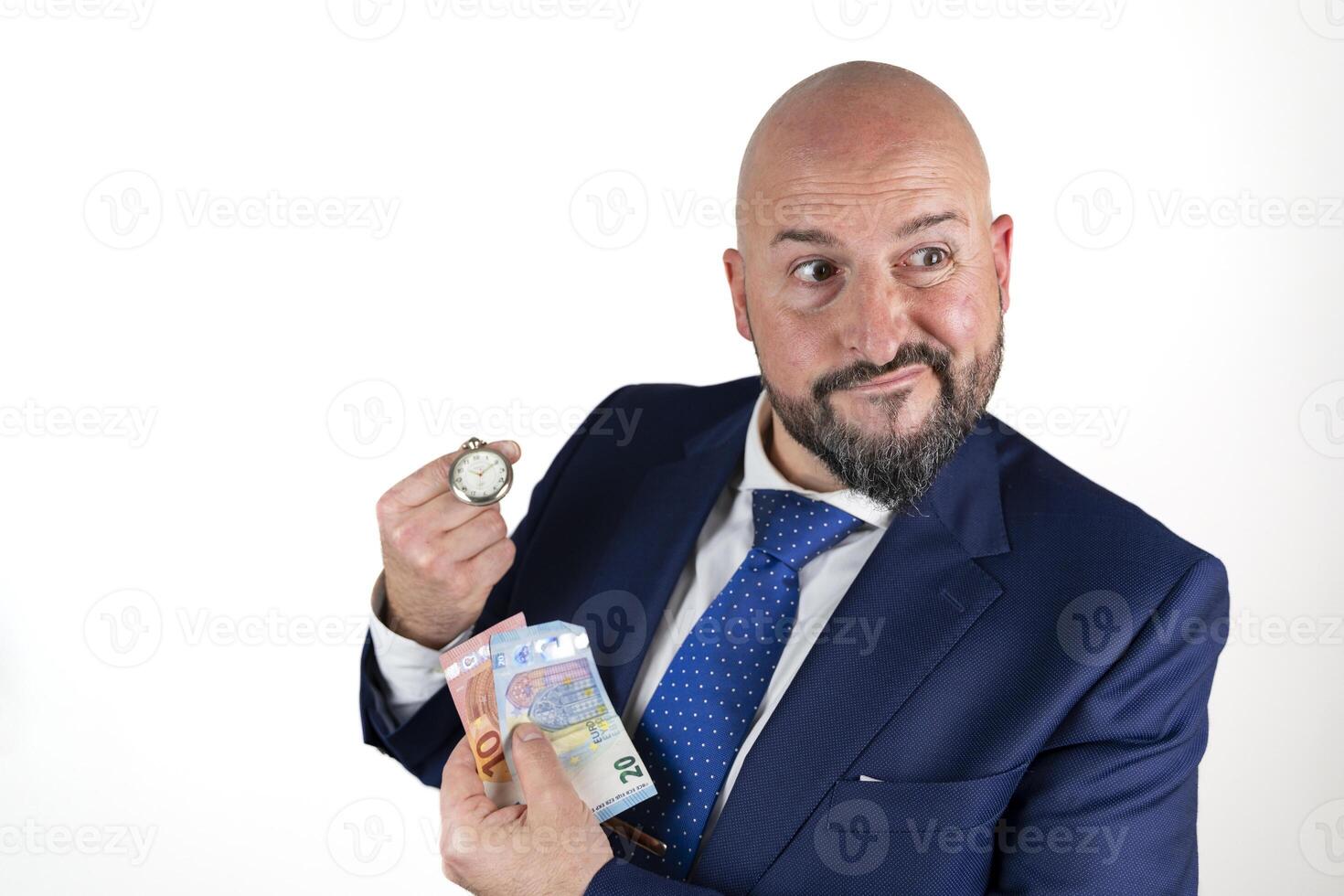 portrait of businessman in blue suit and tie with friendly expression showing a watch and banknotes isolated on white background photo