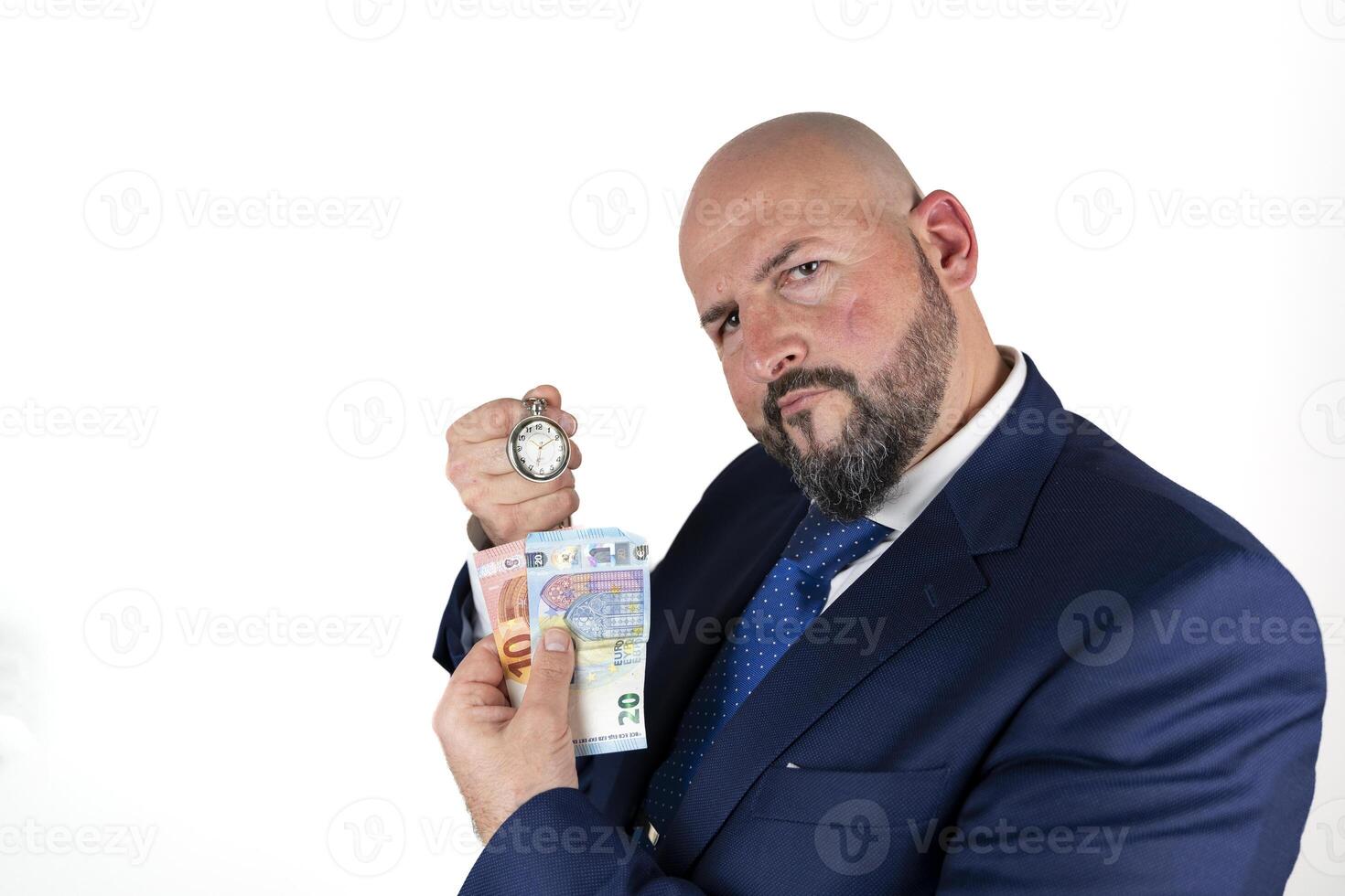 portrait of businessman in blue suit and tie with friendly expression showing a watch and banknotes isolated on white background photo