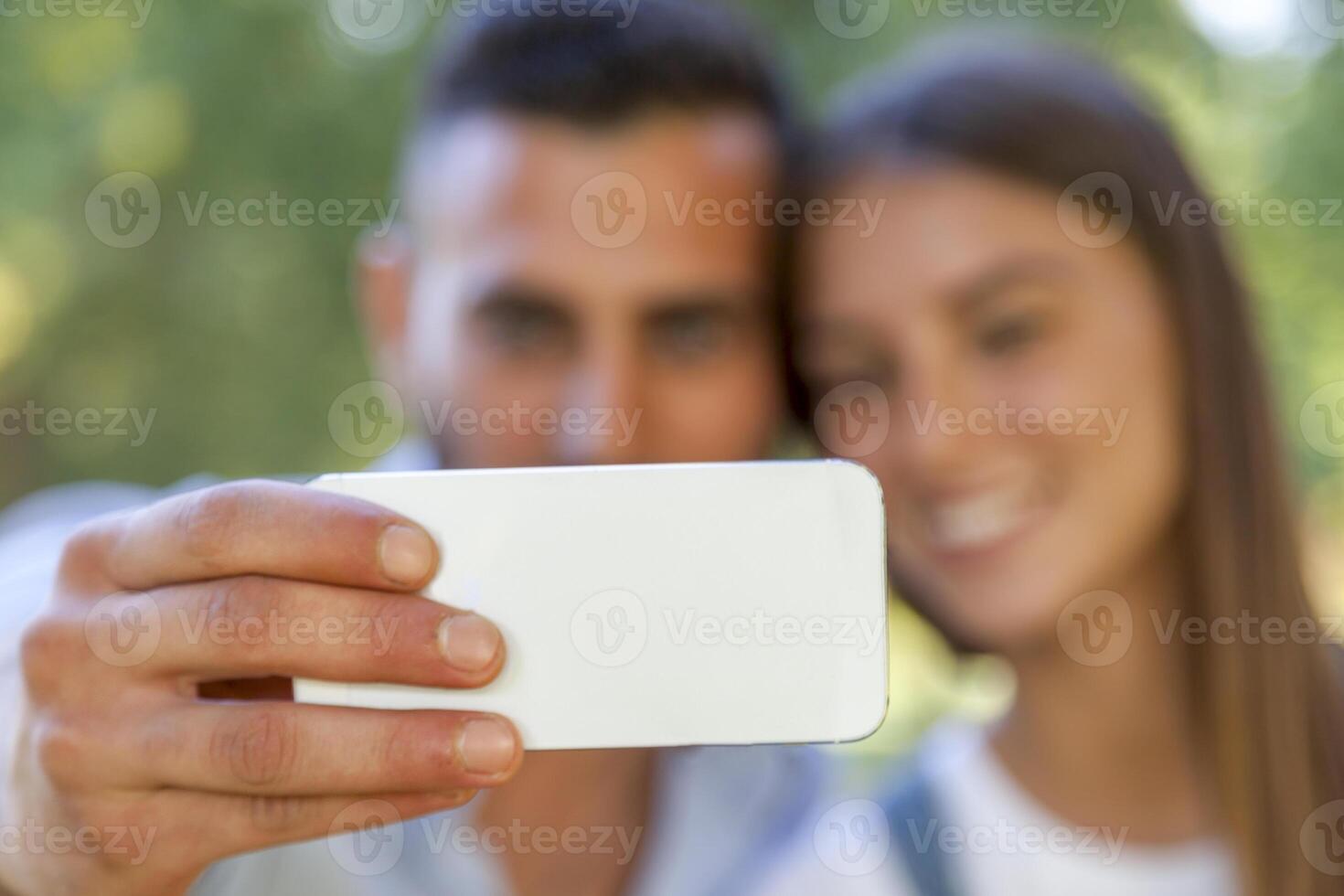 lovely couple of young adults take a selfie in the park photo