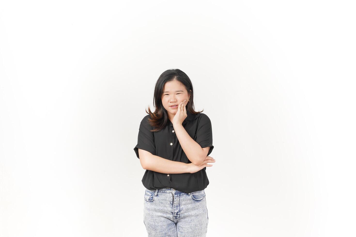 beautiful Asian woman poses with a pained expression, holding her cheek in discomfort due to a toothache against a white background photo