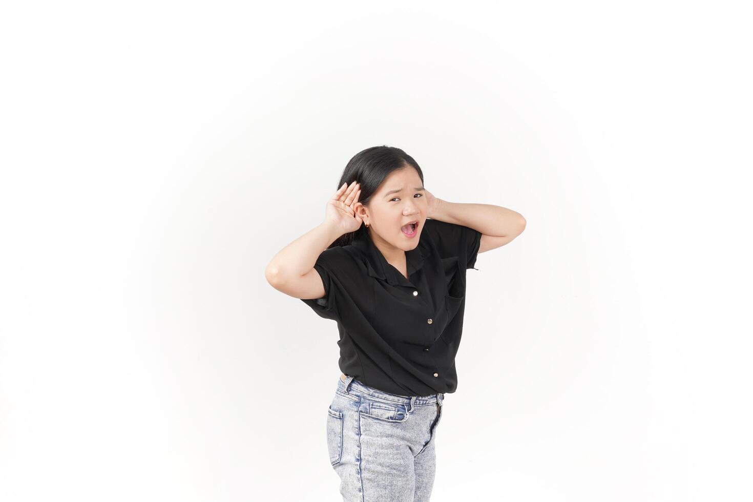 beautiful Asian woman poses with her hands on both ears, trying to listen attentively against a white background photo