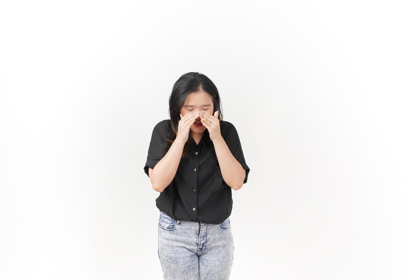 beautiful Asian woman appears to sneeze, displaying allergy symptoms with a hand covering her nose, set against a white background photo