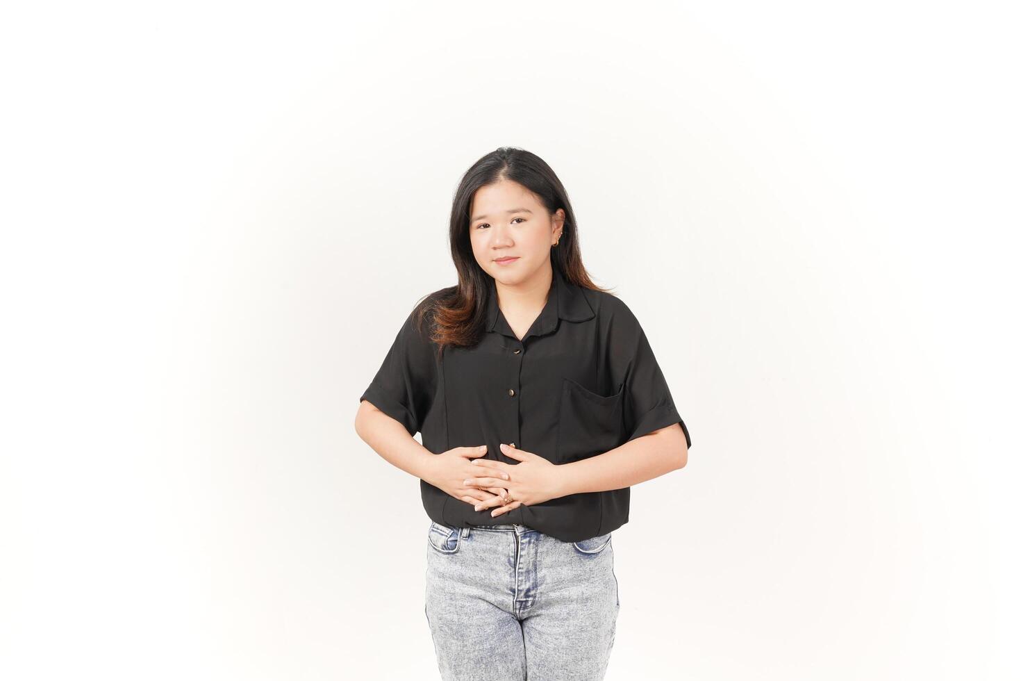 beautiful Asian woman clutches her stomach with both hands, showing discomfort from a stomach ache against a white background photo