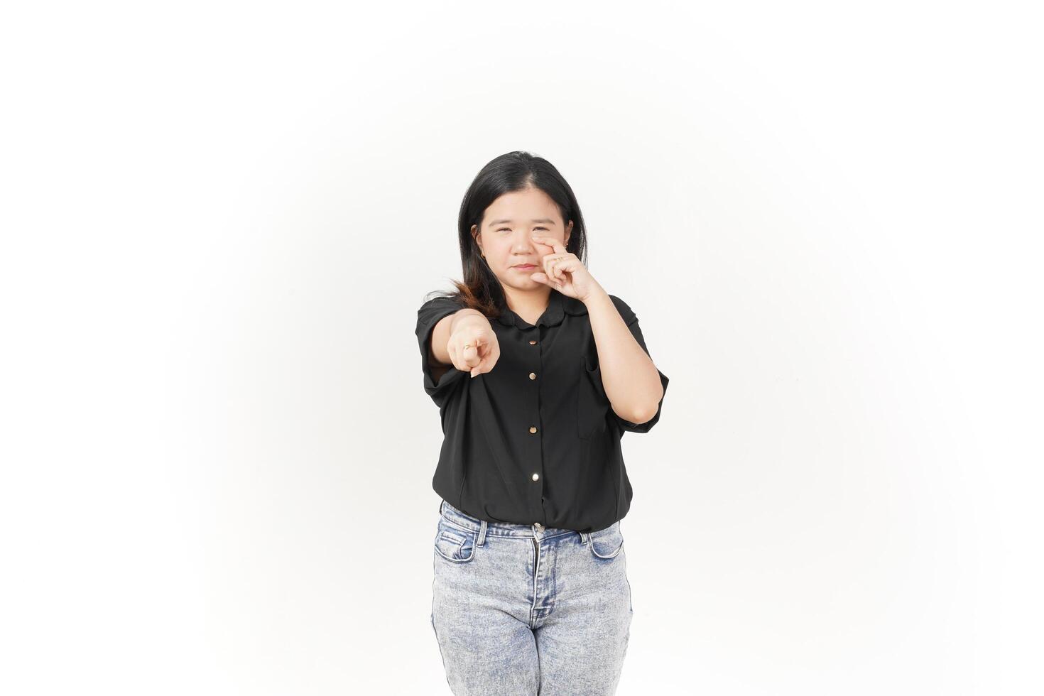 beautiful Asian woman poses with her fingers under her eyes, capturing a poignant crying expression against a white background photo