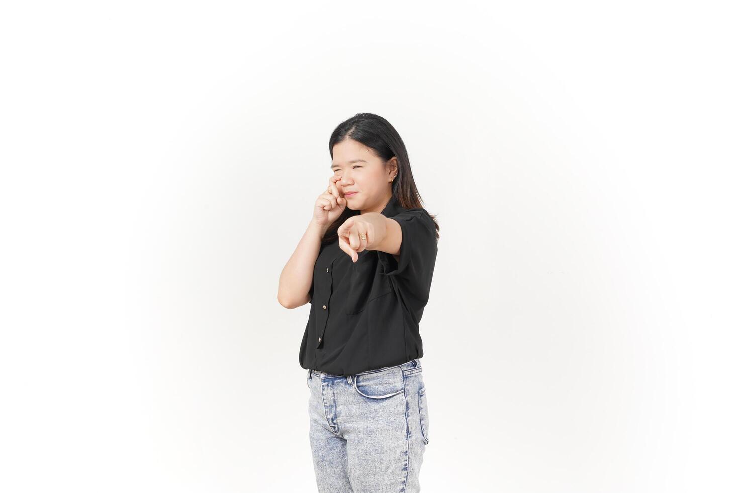 beautiful Asian woman poses with her fingers under her eyes, capturing a poignant crying expression against a white background photo