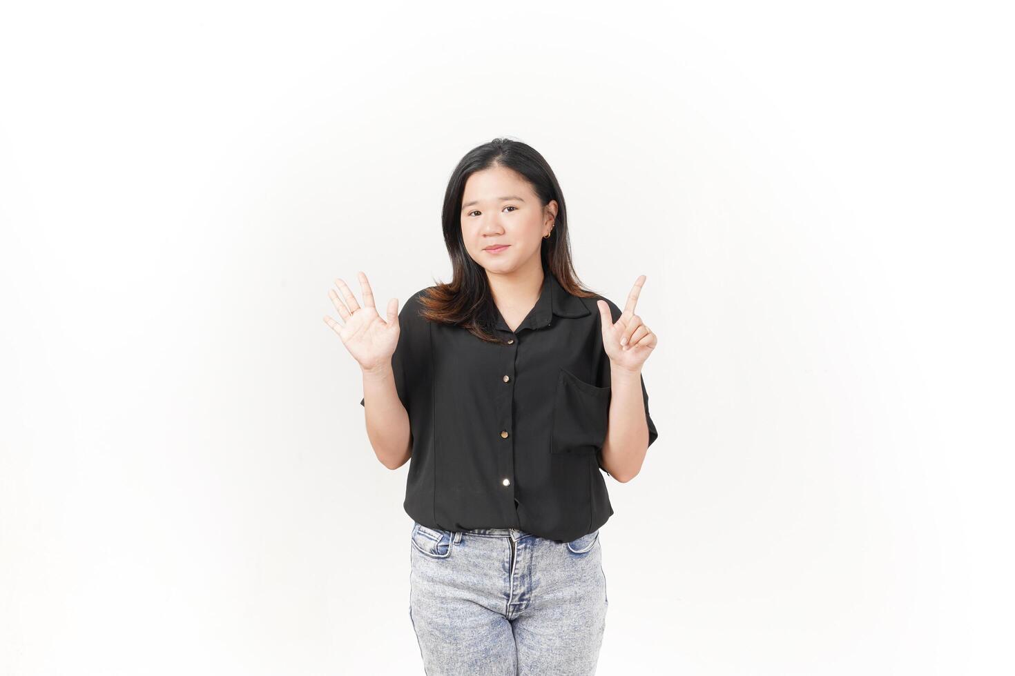 beautiful Asian woman poses with her hands to display the number seven against a clean white background photo