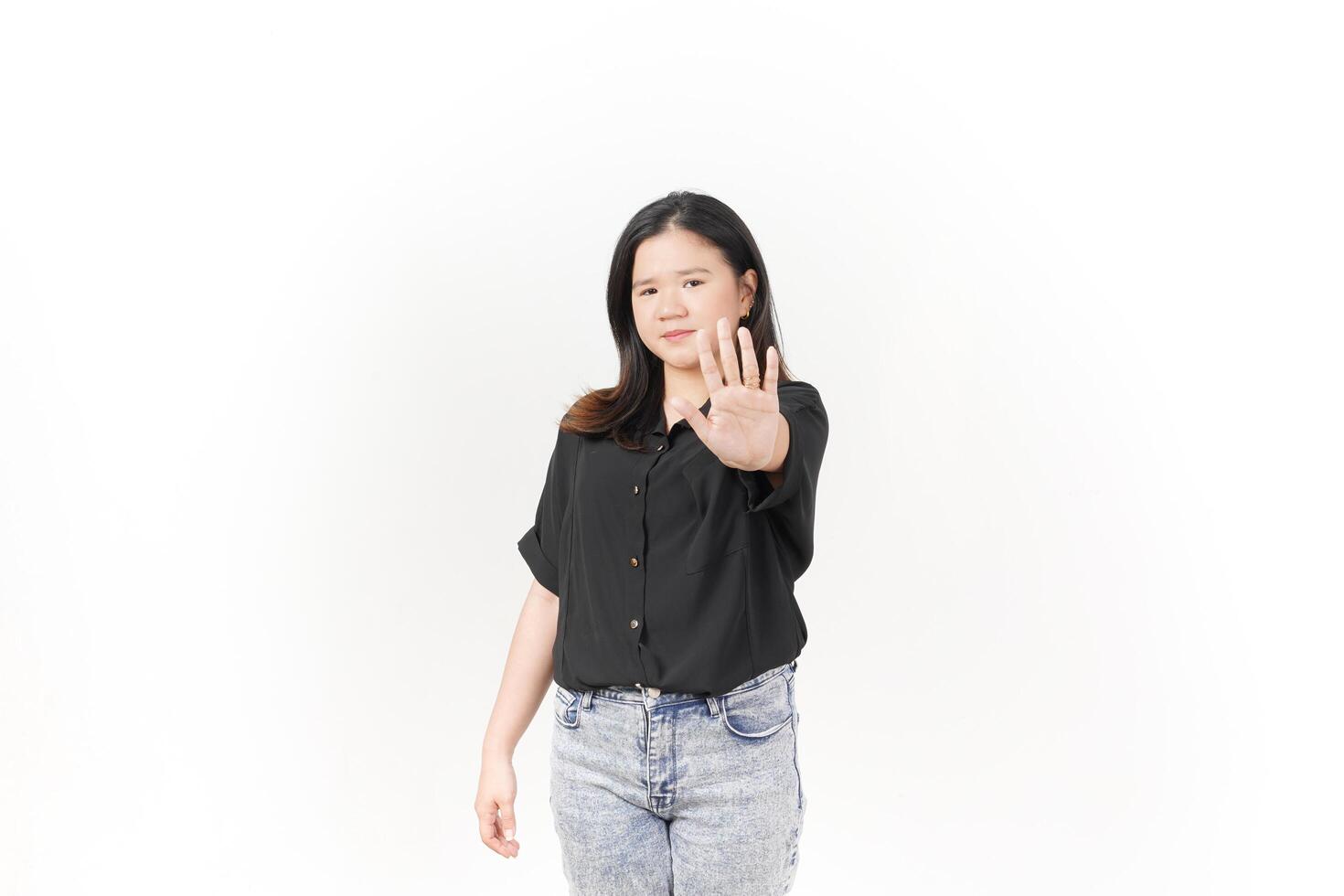 beautiful Asian woman poses with her hands raised in a 'no' gesture against a clean white background photo
